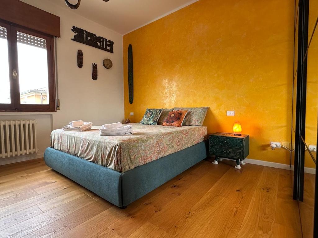 a bedroom with a bed and a yellow wall at Venezia-Mestre Train Station Relax Suites in Venice