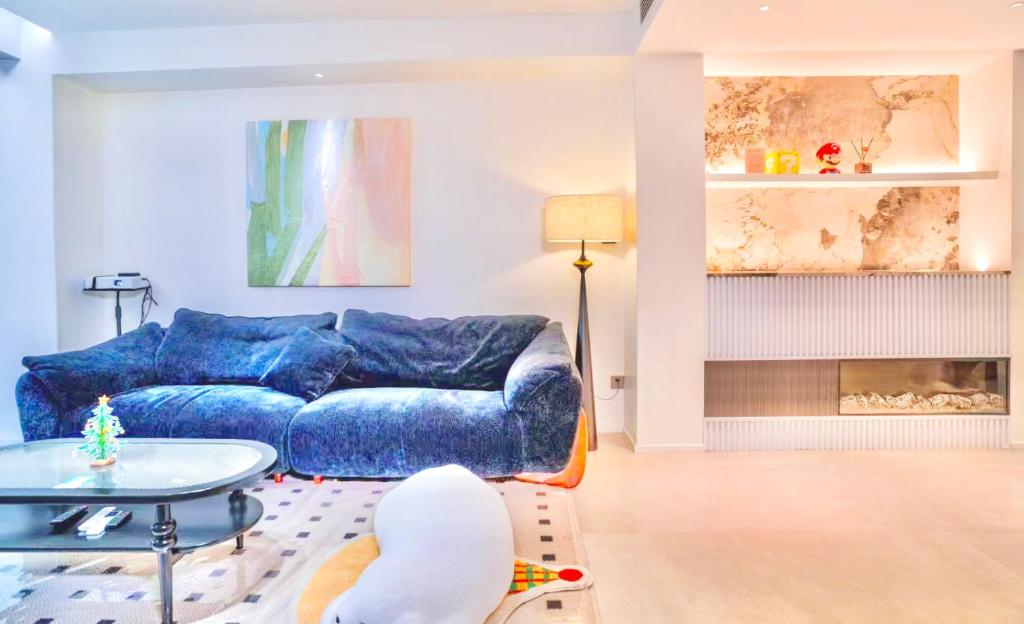 a living room with a blue couch and a table at 4 RMs city APT, Easy to go all attractions in Zhangjiajie