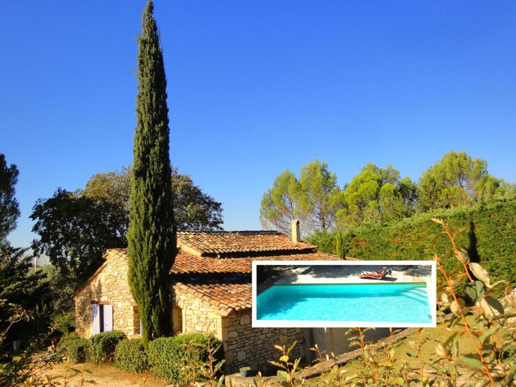 eine Villa mit Swimmingpool und Baum in der Unterkunft Les Olives in Uzès