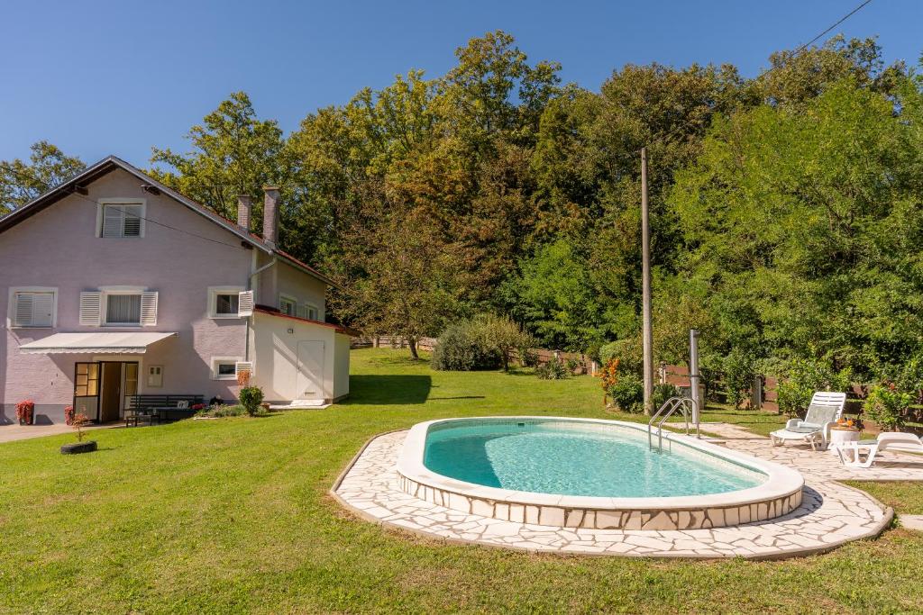 een achtertuin met een zwembad en een huis bij Kuća za odmor Mažuran in Karlovac