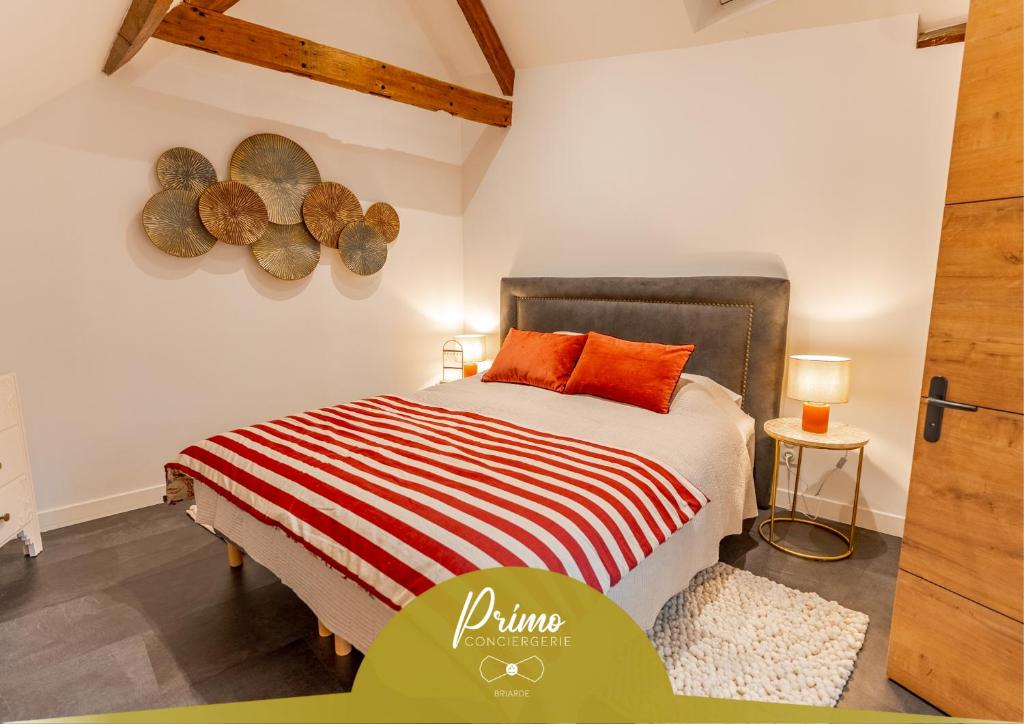 a bedroom with a bed with orange pillows on it at L'authentique, Chic, relaxant et entrée autonome in Coulommiers