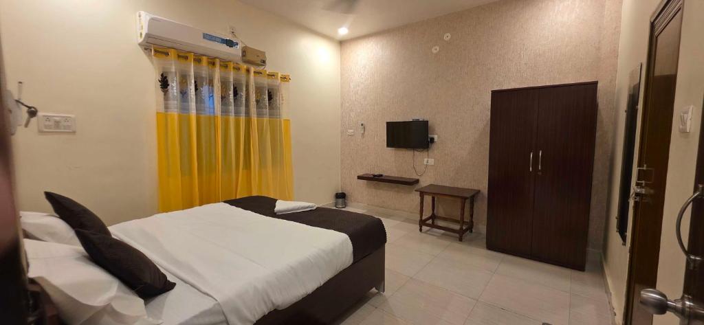 a bedroom with a bed and a yellow curtain at Hotel O Banaras Guest House in Banāras Cantonment