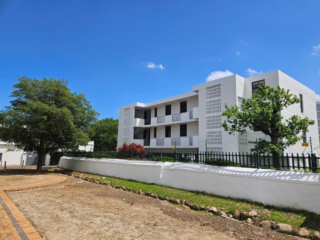 a white building with a fence in front of it at PinotageLuxuryCollection 14 Bastmolen in Stellenbosch