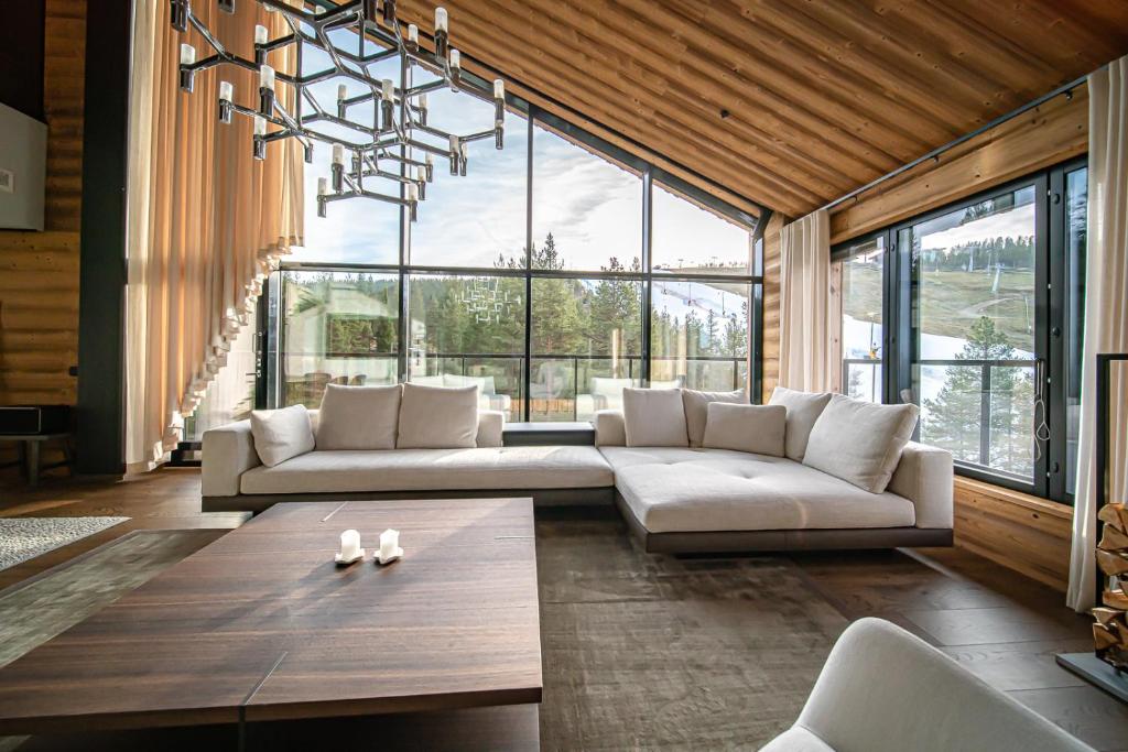 a living room with a couch and a large window at Le Chalet Royal by Aavalevi in Levi