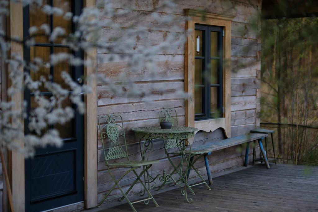 a table and chair on a porch next to a building at Kukučio ausy in Trasninkas