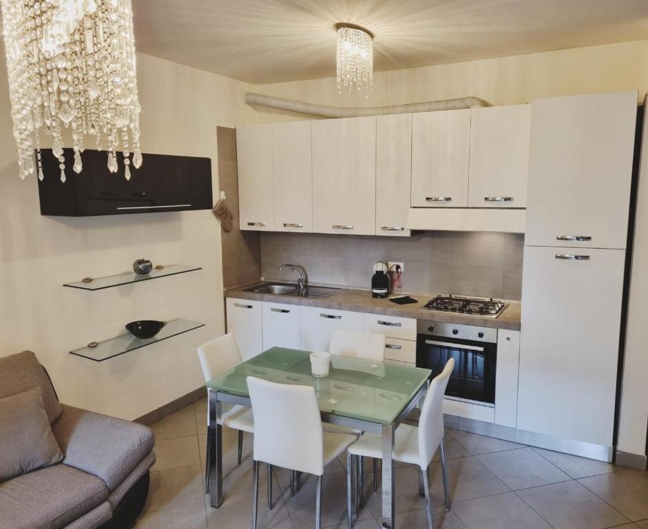 een keuken met witte kasten en een tafel en stoelen bij Maison Carducci in Imola