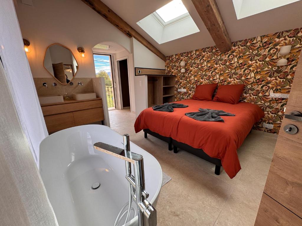 a bedroom with a bed and a bath tub at La Master Grange De Queyran in La Palud sur Verdon
