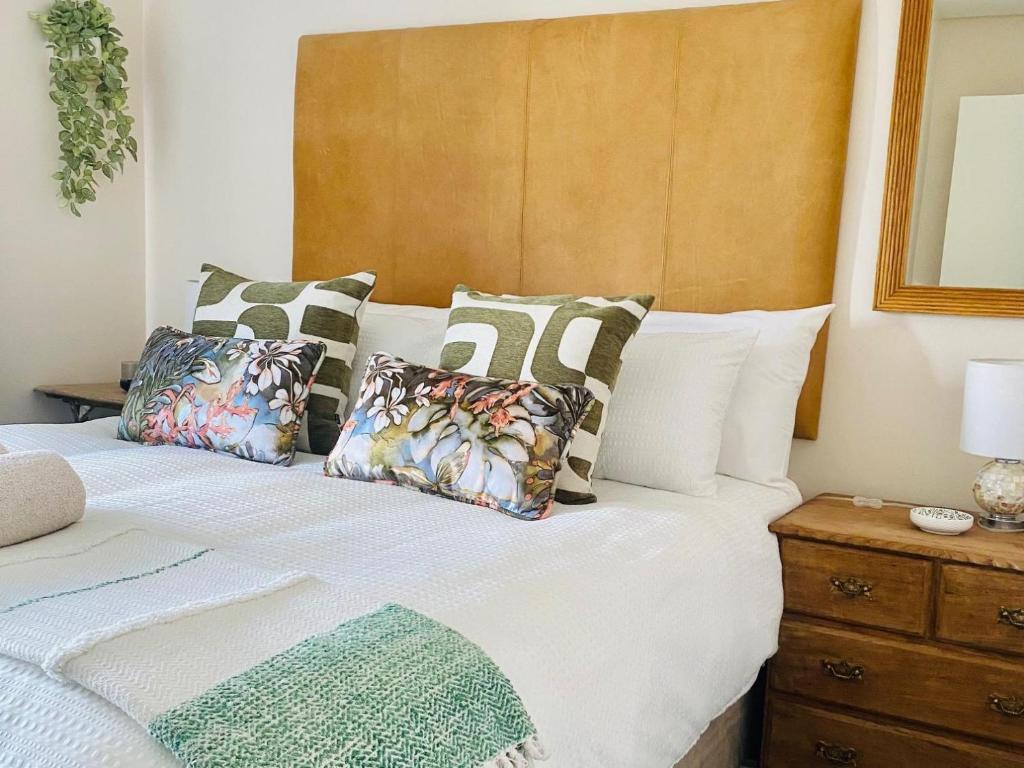 a bedroom with a bed with a wooden headboard and pillows at Wild Olive at 51 in Windhoek