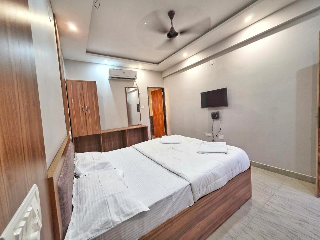 a bedroom with a large bed and a tv at The Urban Escape in Udupi