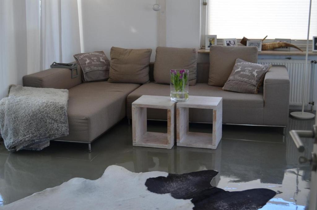 een woonkamer met een bank en twee tafels bij Haus Speckgürtel Hamburg in Henstedt-Ulzburg