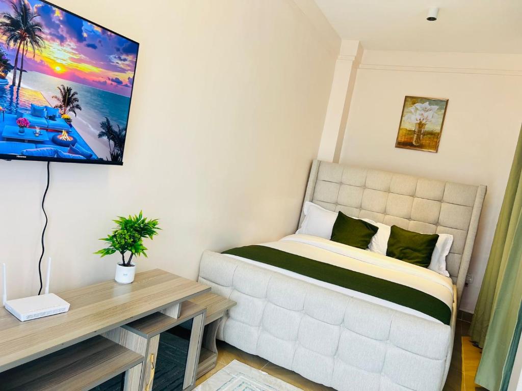 een slaapkamer met een bed en een tv aan de muur bij Ww Homes in Nairobi