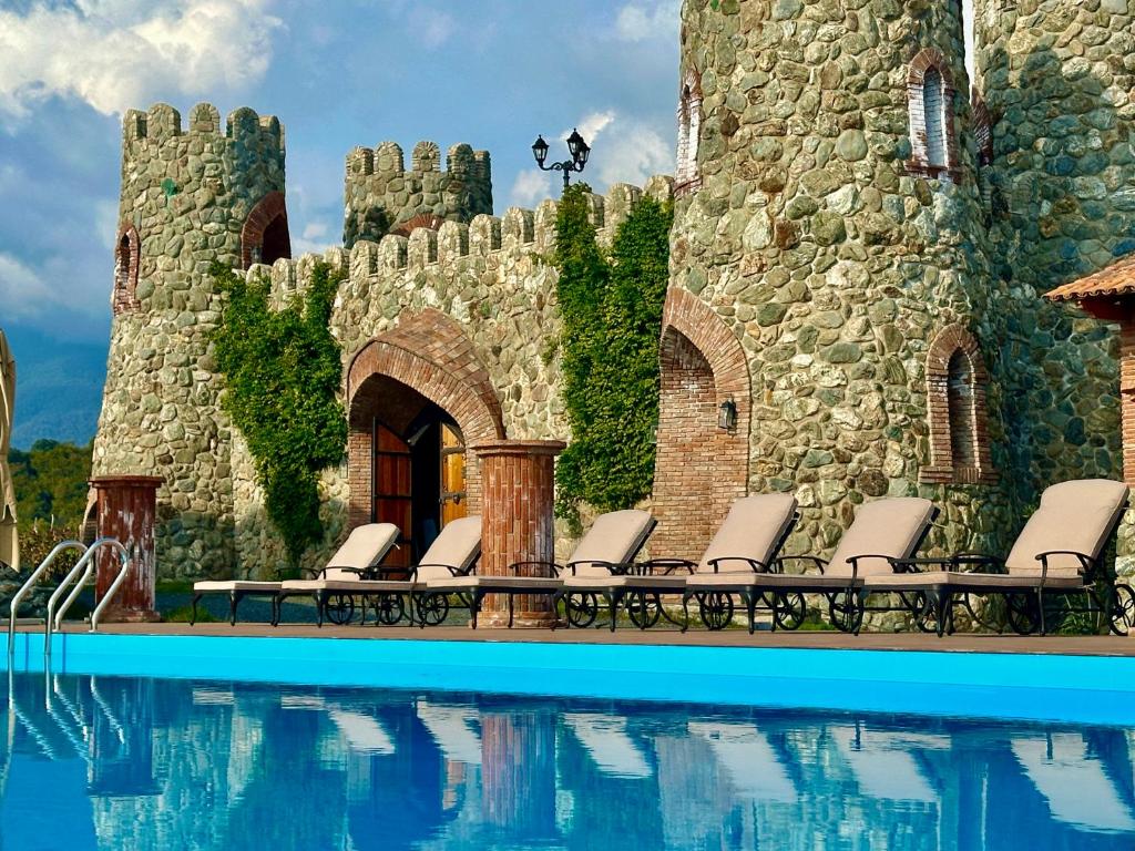 a group of chairs next to a building with a swimming pool at Javakhishvilebis Marani in Akhalsopʼeli
