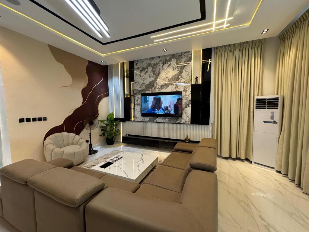 a living room with a couch and a tv at Danjo Shortlets in Aja