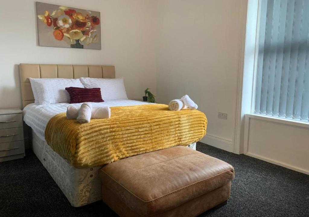 ein Schlafzimmer mit einem Bett mit einer gelben Decke in der Unterkunft A&A Luxury Stay Tunstall in Sunderland