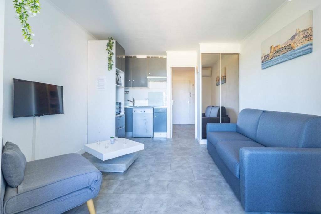 a living room with a blue couch and a tv at La Baie des Anges - Plage à Pied - Garage Privé in La Ciotat