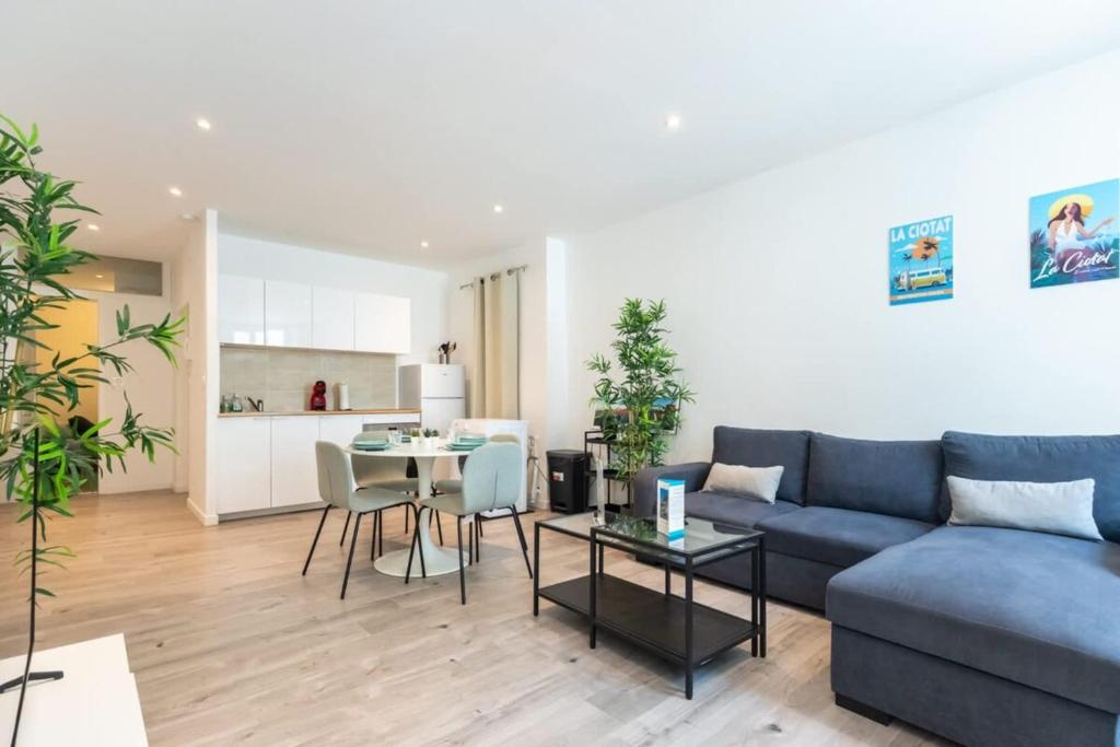 a living room with a blue couch and a table at L'Olivier - Centre de la Ciotat in La Ciotat