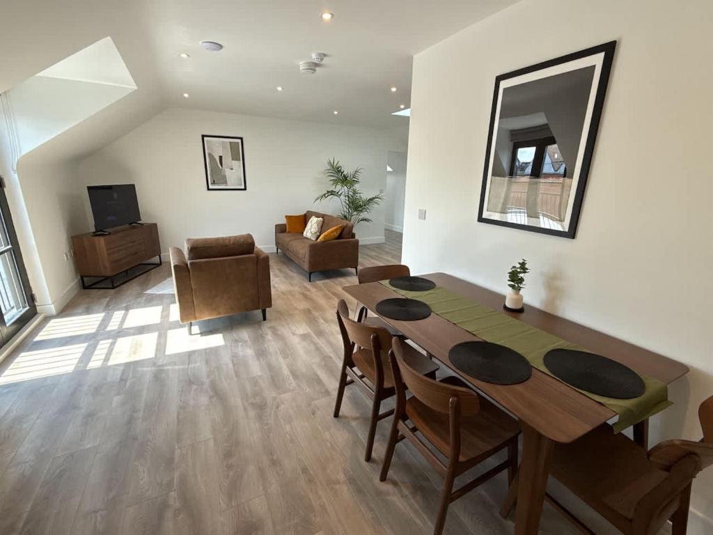 ein Wohnzimmer mit einem Holztisch und ein Wohnzimmer mit einem Sofa in der Unterkunft Penthouse 2 bed 1 bathroom property in centre in Abingdon