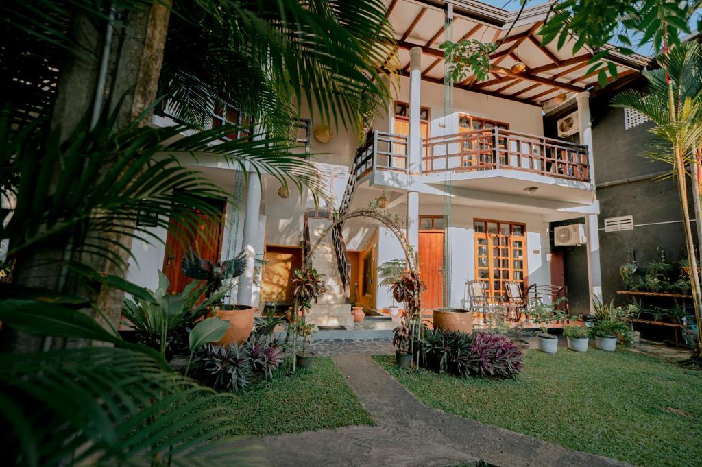 a house with a courtyard with plants and a balcony at DANDELION - Unawatuna in Unawatuna
