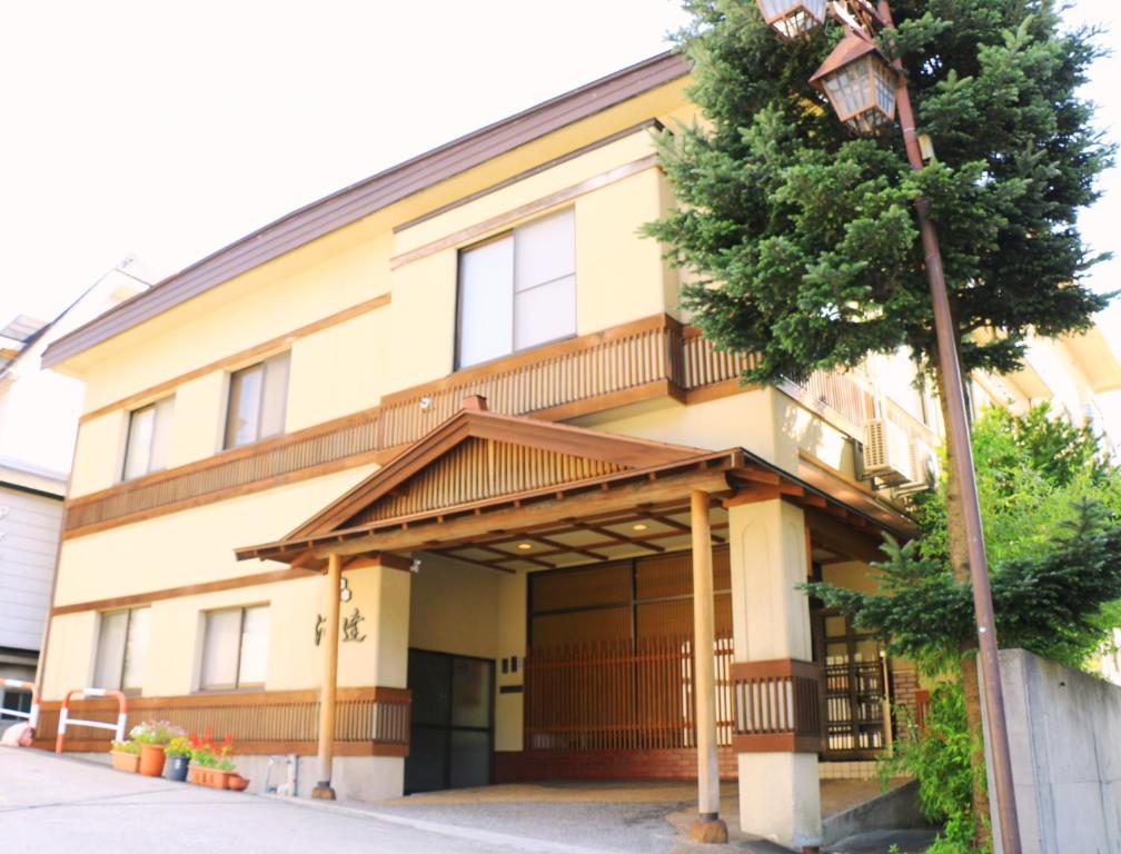 a building with a tree in front of it at Kawatatsu in Nozawa Onsen