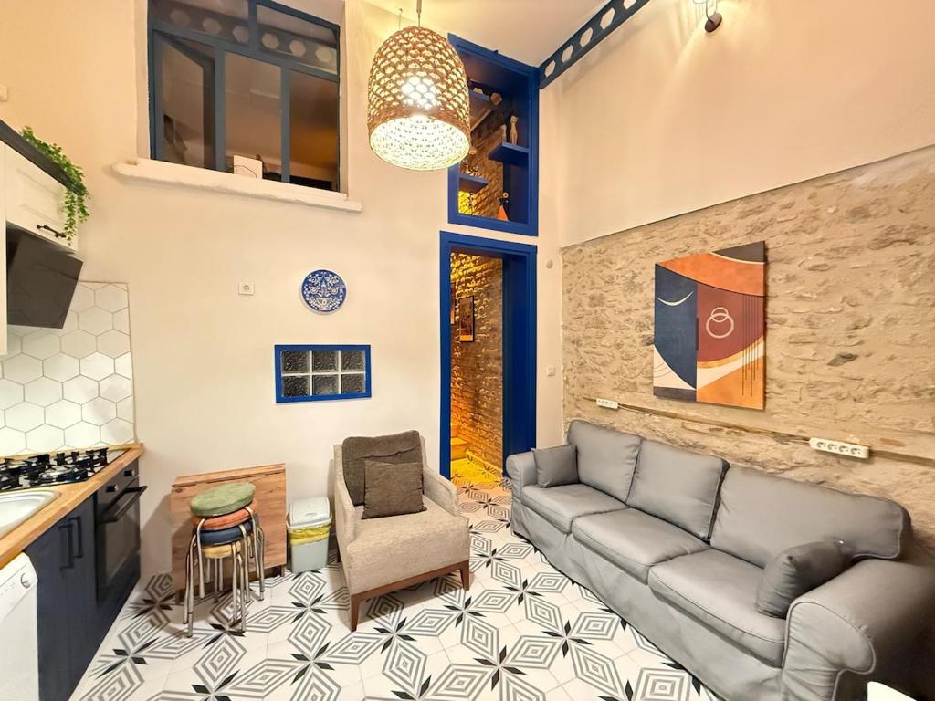 a living room with a couch and a kitchen at Loft Cosy Stone House in Konak