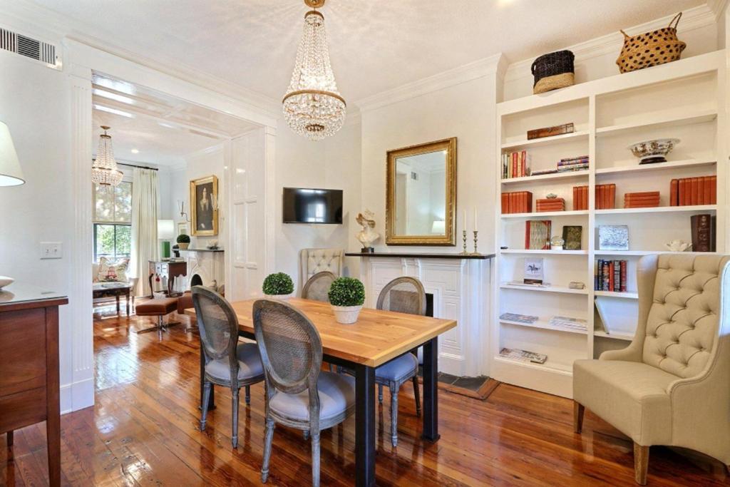 ein Esszimmer mit Tisch und Stühlen und einem Kamin in der Unterkunft Isaac LaRoche Main in Savannah