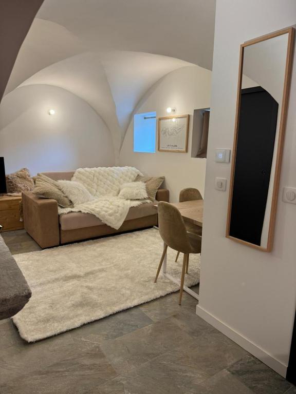 a living room with a bed and a mirror at Chalet La Landonne chaleureux pour 2 in La Combe