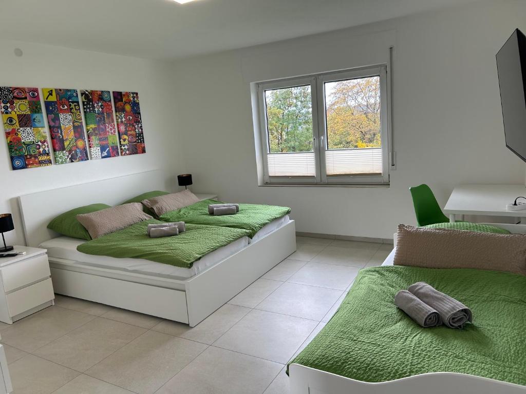 a white bedroom with two beds and a window at Ferienwohnung Eyb in Ansbach
