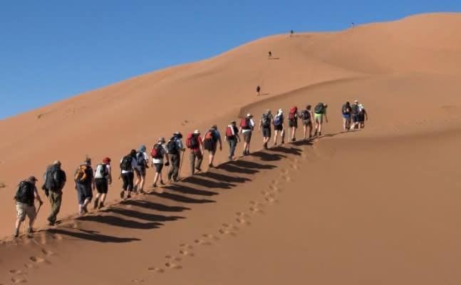 un grupo de personas caminando por el desierto en Guest house familly, en Adrouine