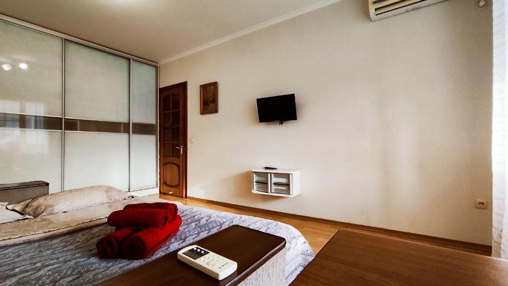 a bedroom with a bed and a tv on the wall at Олександрійський б-р 125 CityRooms in Bila Tserkva