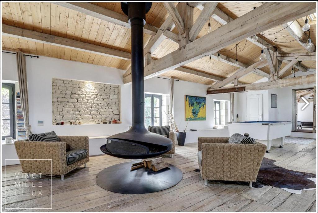 een open woonkamer met een open haard in het midden bij Le loft in Croix-Chapeau