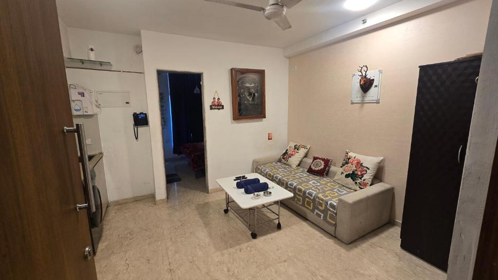 ein Wohnzimmer mit Sofa und Tisch in der Unterkunft Studio Apartment - 4pax - Hiranandani Estate in Thane