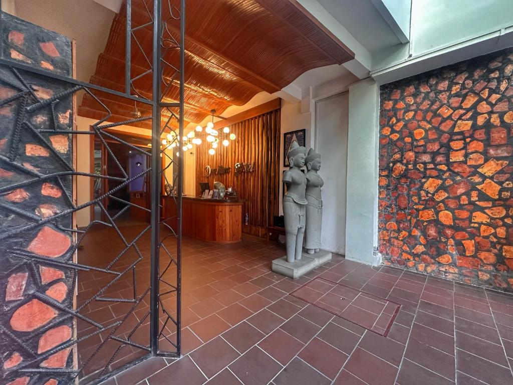 金边Downtime Hotel Phnom Penh的大厅墙上有一尊两个人的雕像。