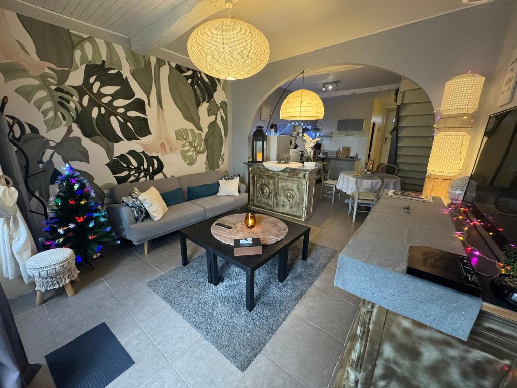 a living room with a couch and a christmas tree at la Salaberie & SPA in Villeréal