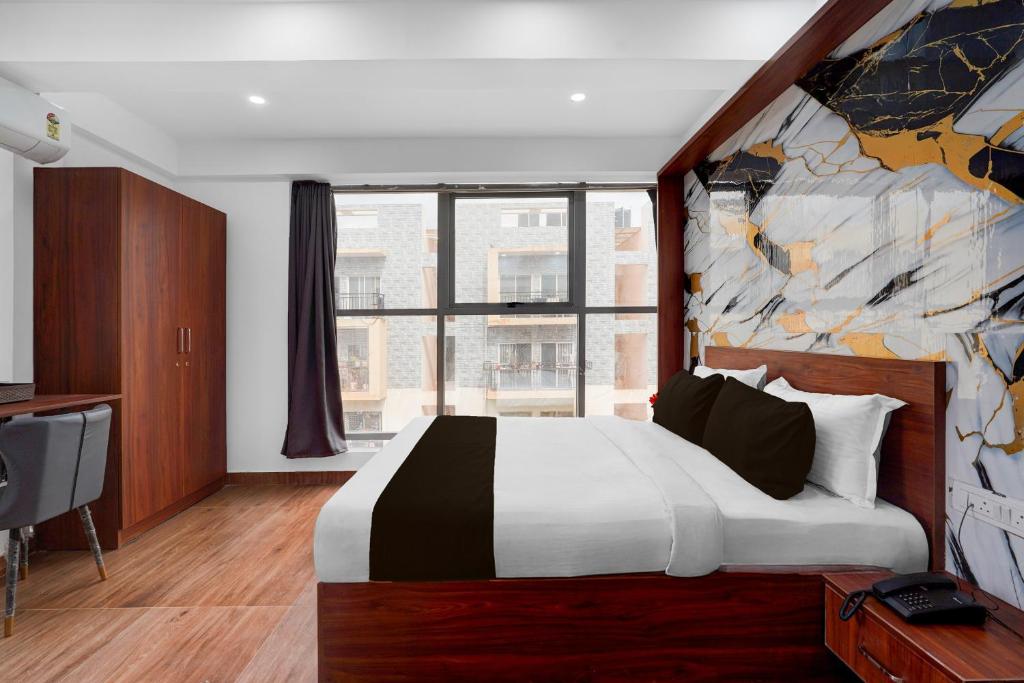 a bedroom with a large bed and a large window at Super Townhouse Whitefield Railway Station Formerly Kadugudi Whitefield in Bangalore