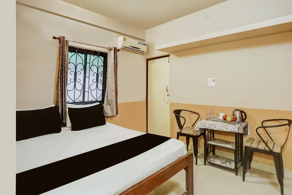 een slaapkamer met een bed, een tafel en een raam bij Hotel O Arambol Beach Formerly Hakuna Matata in Arambol