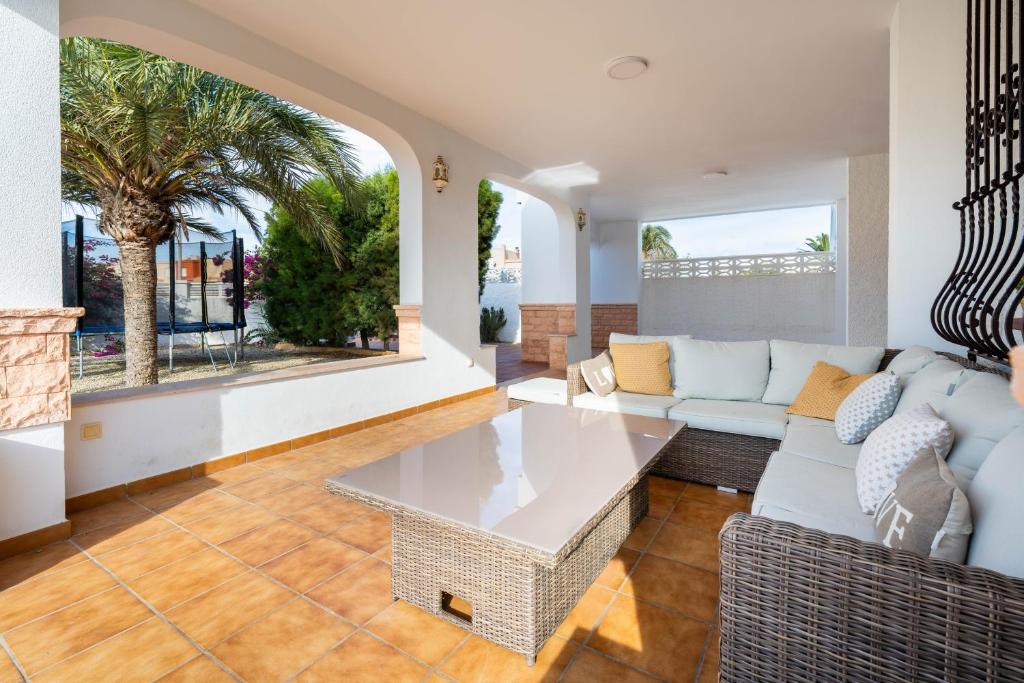 een woonkamer met een bank en een tafel bij Casa en Cabo de Gata con barbacoa y Jardín, cerca de la playa in El Cabo de Gata
