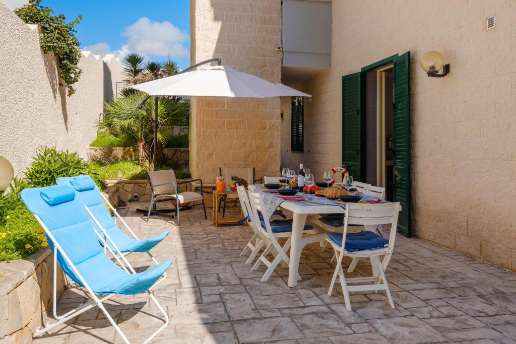a patio with a table and chairs and an umbrella at Costal Vibe in Isola della Malva