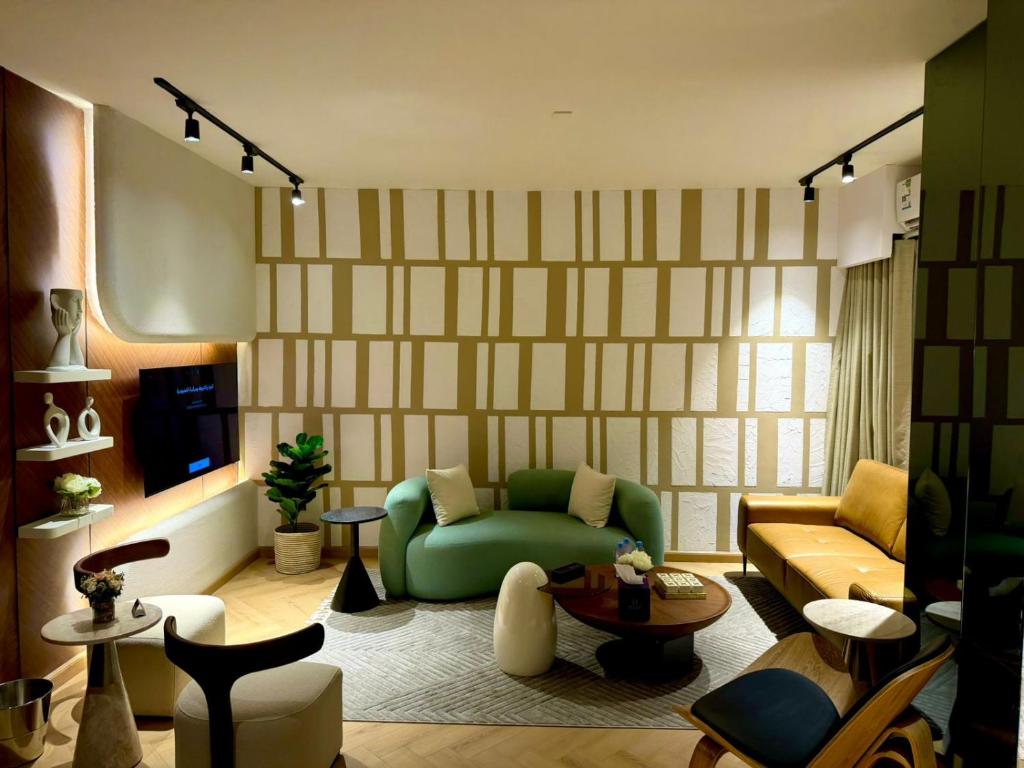 a living room with a green couch and a tv at D3S 3BR Apartment in Makkah