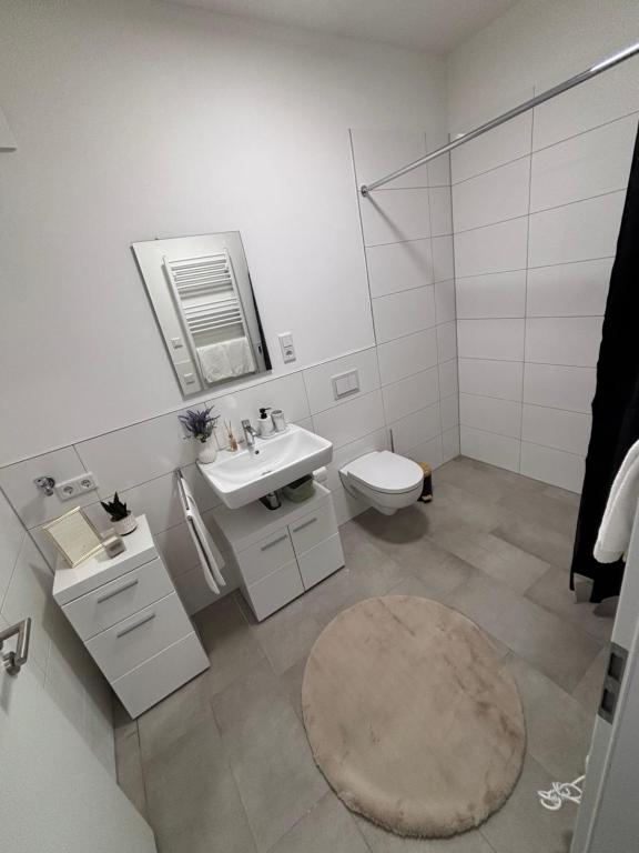 a white bathroom with a sink and a toilet at Zentrales, neumodernes Apartmentment Püttquartier No 3 in Ibbenbüren