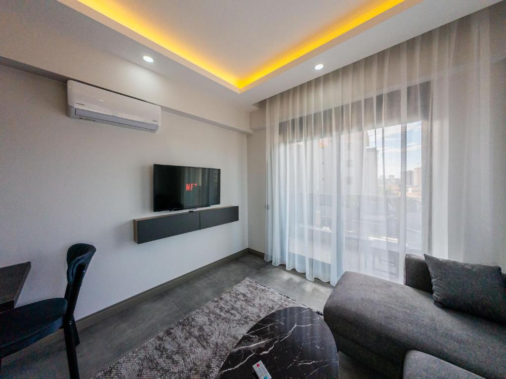 a living room with a couch and a tv at Dorado Suit in Aksu