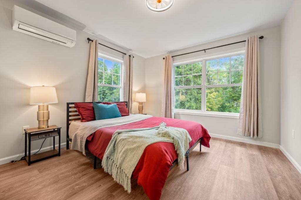 a bedroom with a bed and two windows at Spacious House with King Beds in Prime Location in Bloomfield