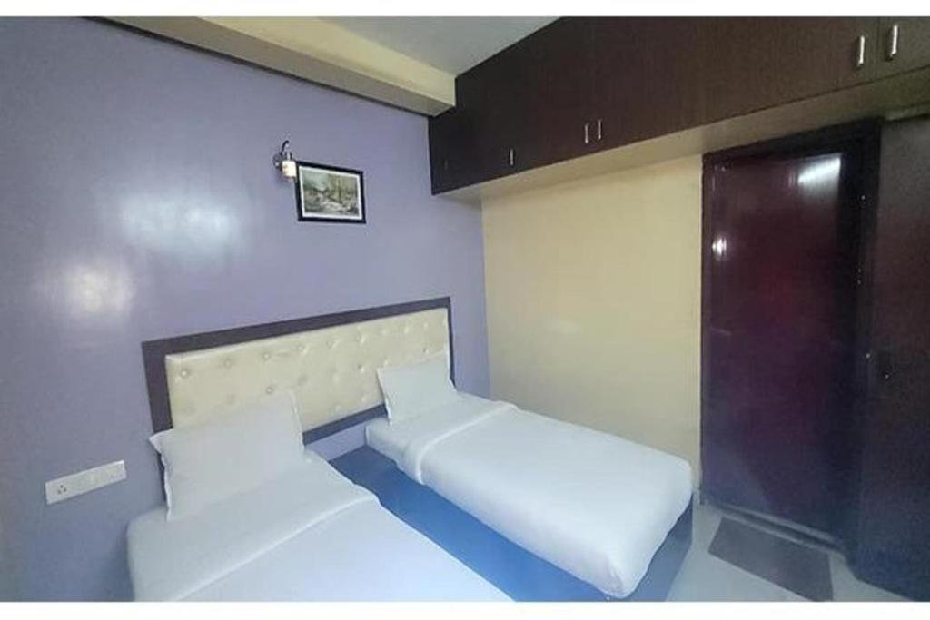 a small room with two beds and a door at Via Blue Moon Residency in Chennai