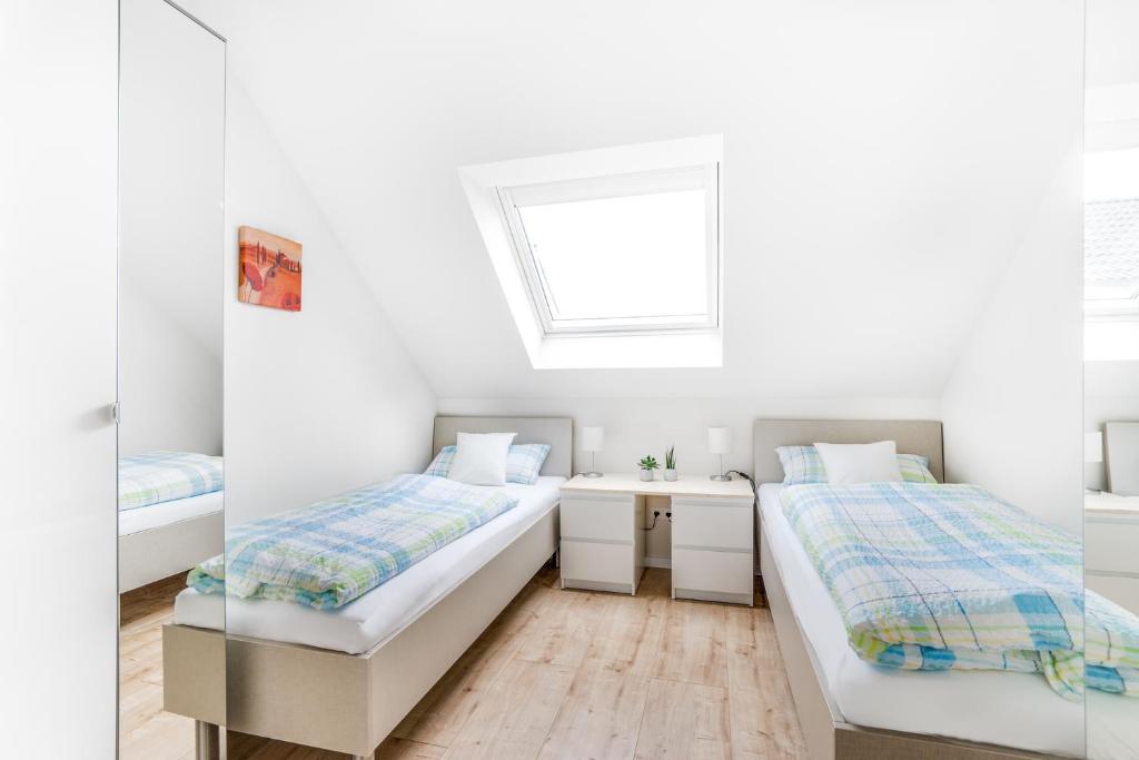 NickenichFerienwohnungen Pellenzblick - Wohnen auf Zeit -的配有水槽和窗户的客房内的两张床