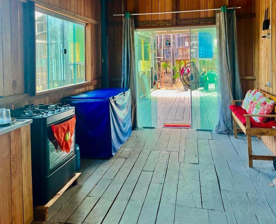 a kitchen with a stove and a door to a room at Recanto Paraiso Tropical- Praia Ajuruteua in Bragança