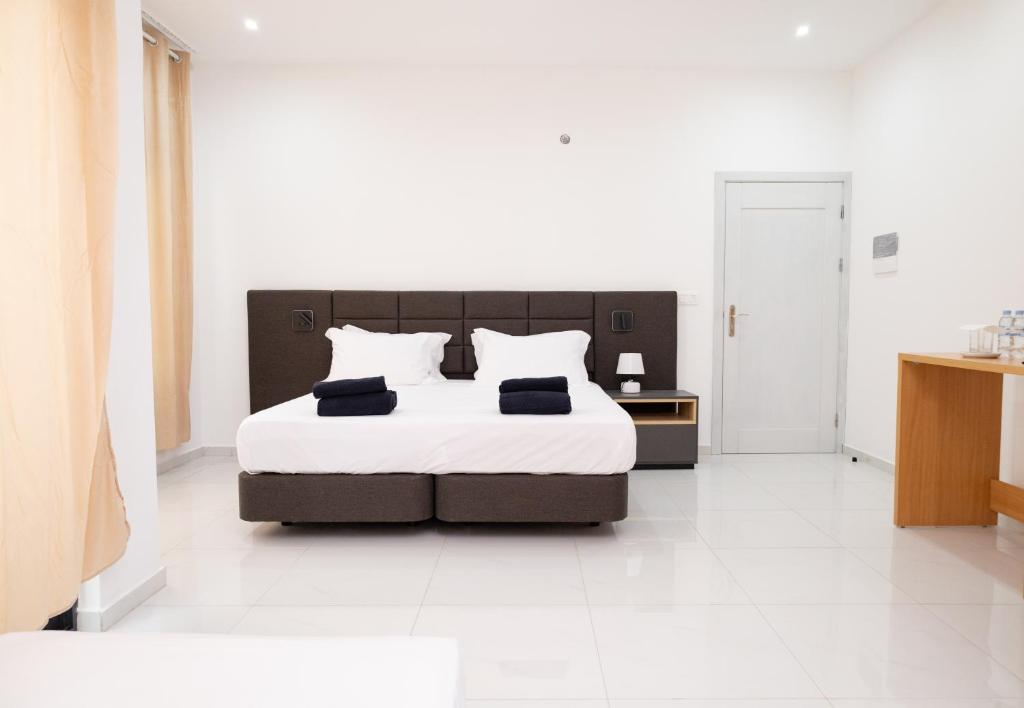 1 dormitorio con 1 cama grande y suelo blanco en Apart'hotel Assomada, en Assomada