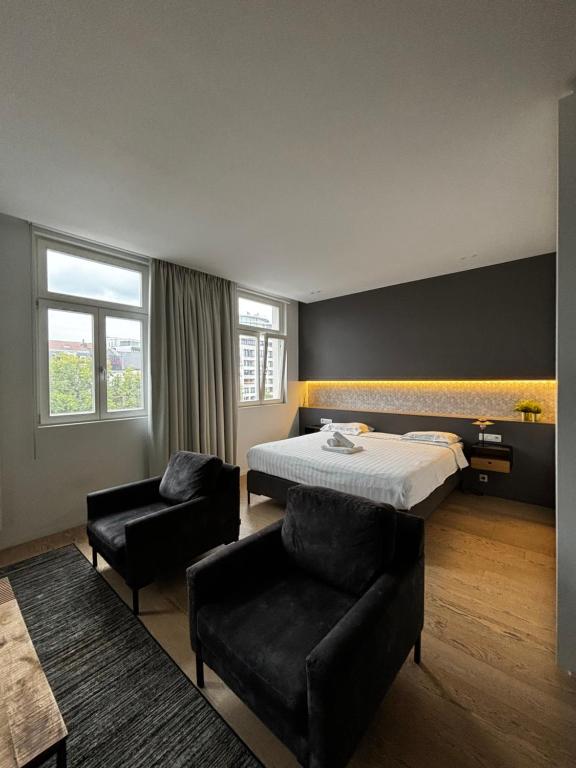 a hotel room with a bed and a chair at Namur Suites in Mellet