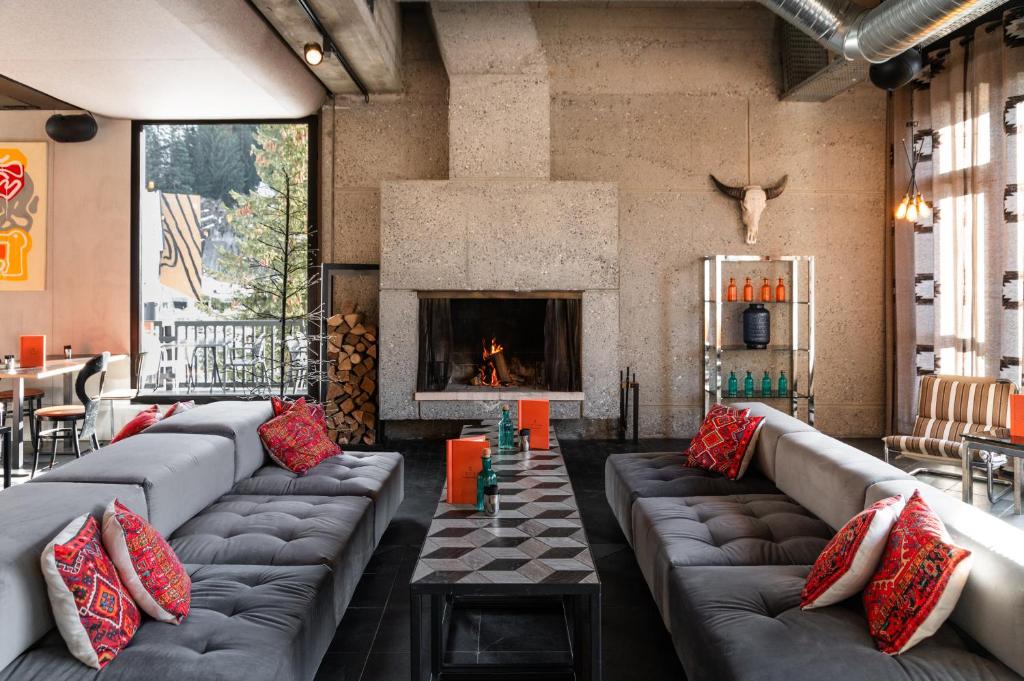 Una sala de estar con sofás y chimenea. en Totem, Friendly Hotel & Spa, en Flaine