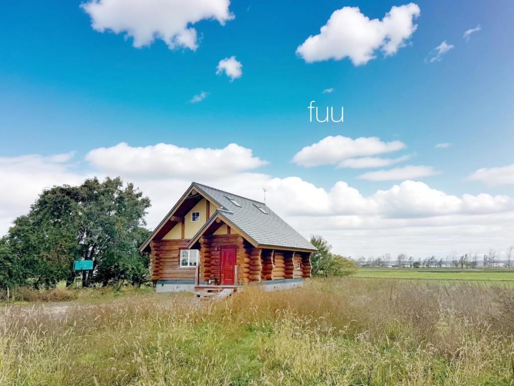 a log cabin in a field with a blue sky at Private Log villa 星空を独占するログハウス新千歳空港35分 自然に癒される貸別荘 in Naganuma