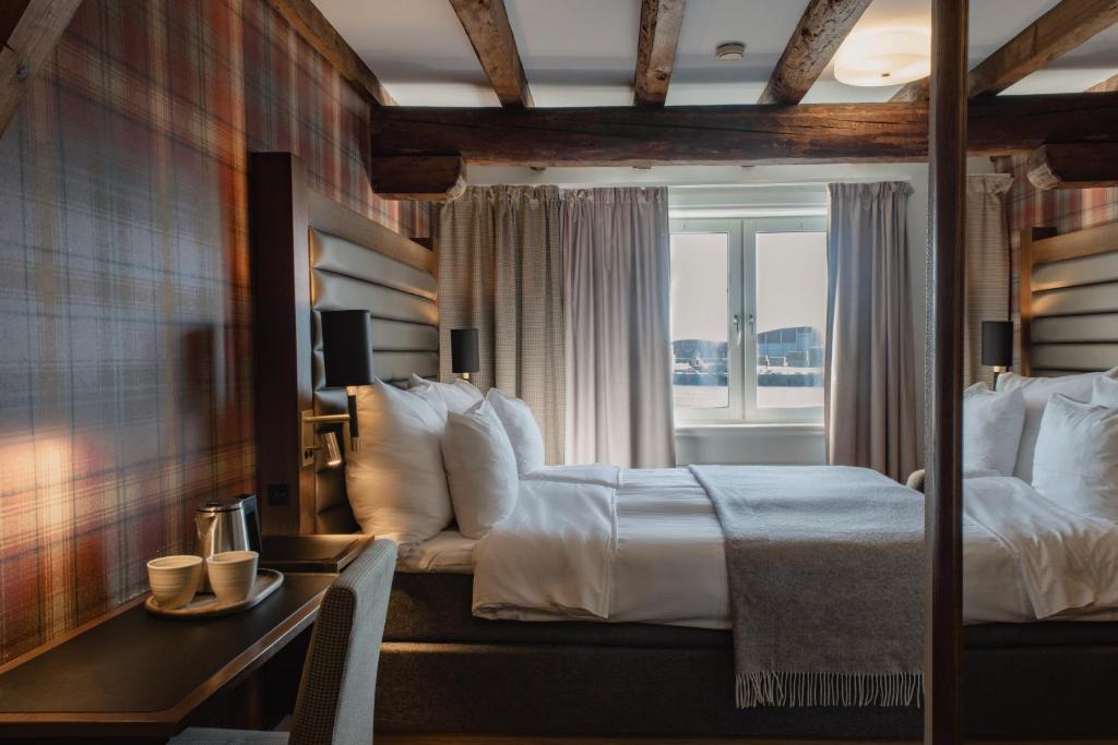 a hotel room with a bed and a window at Home Hotel Packhuset in Kalmar