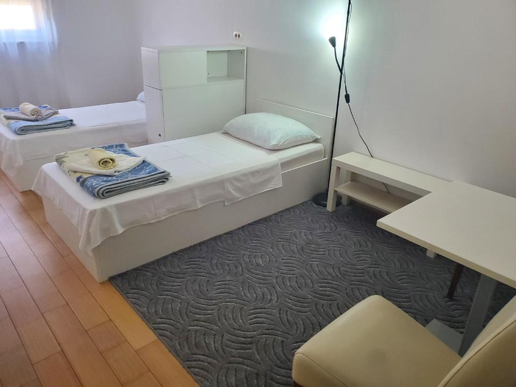 ein kleines Zimmer mit zwei Betten und einem Tisch in der Unterkunft Apartman M in Mostar